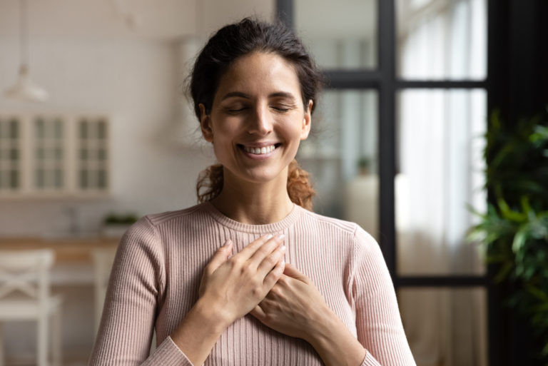 dame debout seule avec les yeux fermés gardez les mains près du cœur
