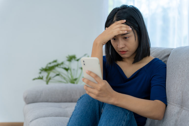 femme triste tenant le téléphone
