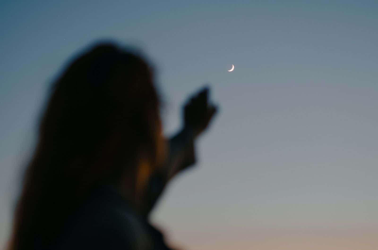 femme pointant vers la lune