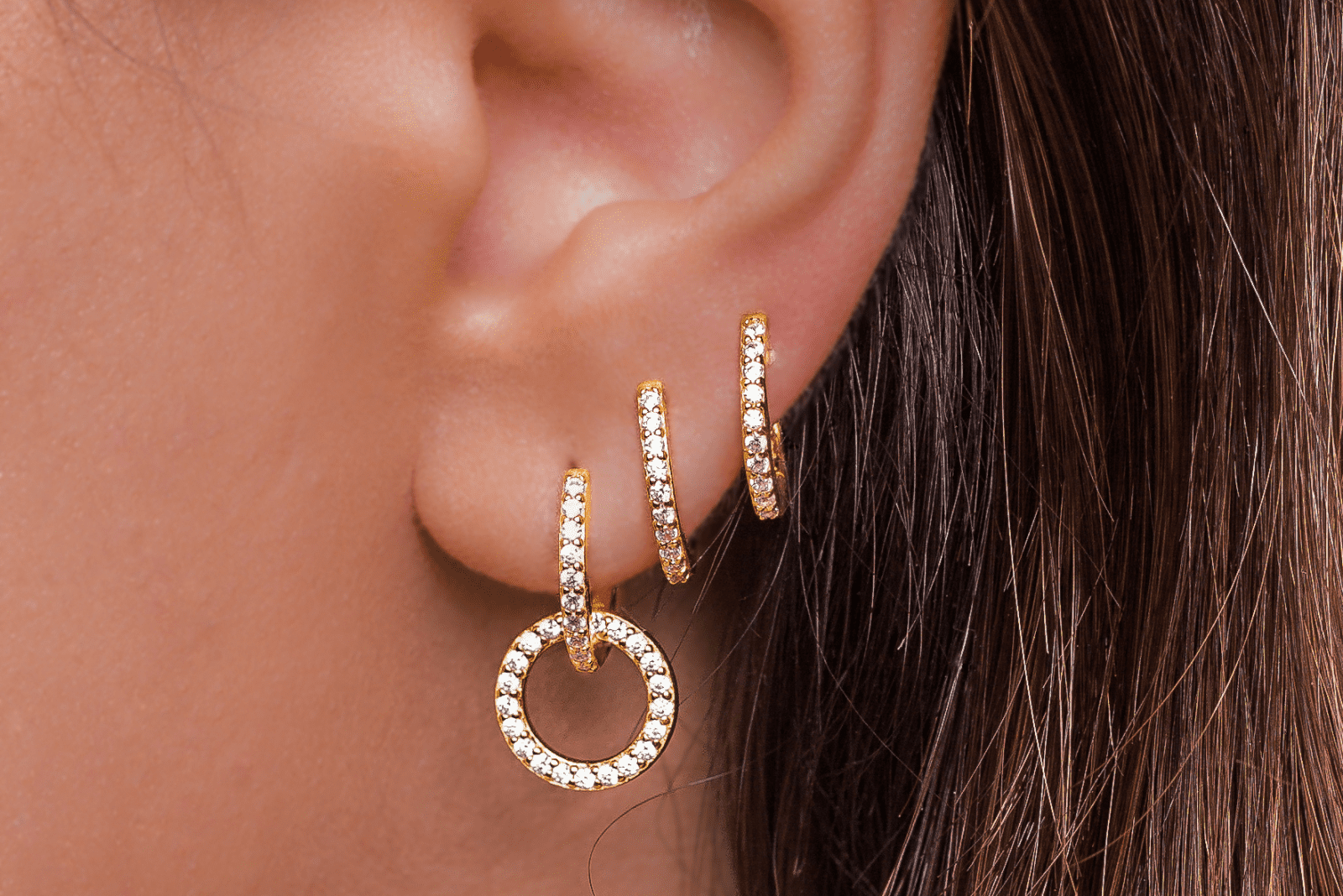 une femme avec des piercings d'oreille en or