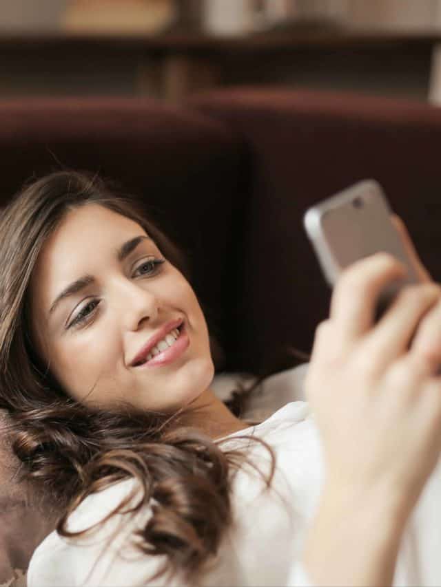 une fille tient un téléphone et envoie des SMS
