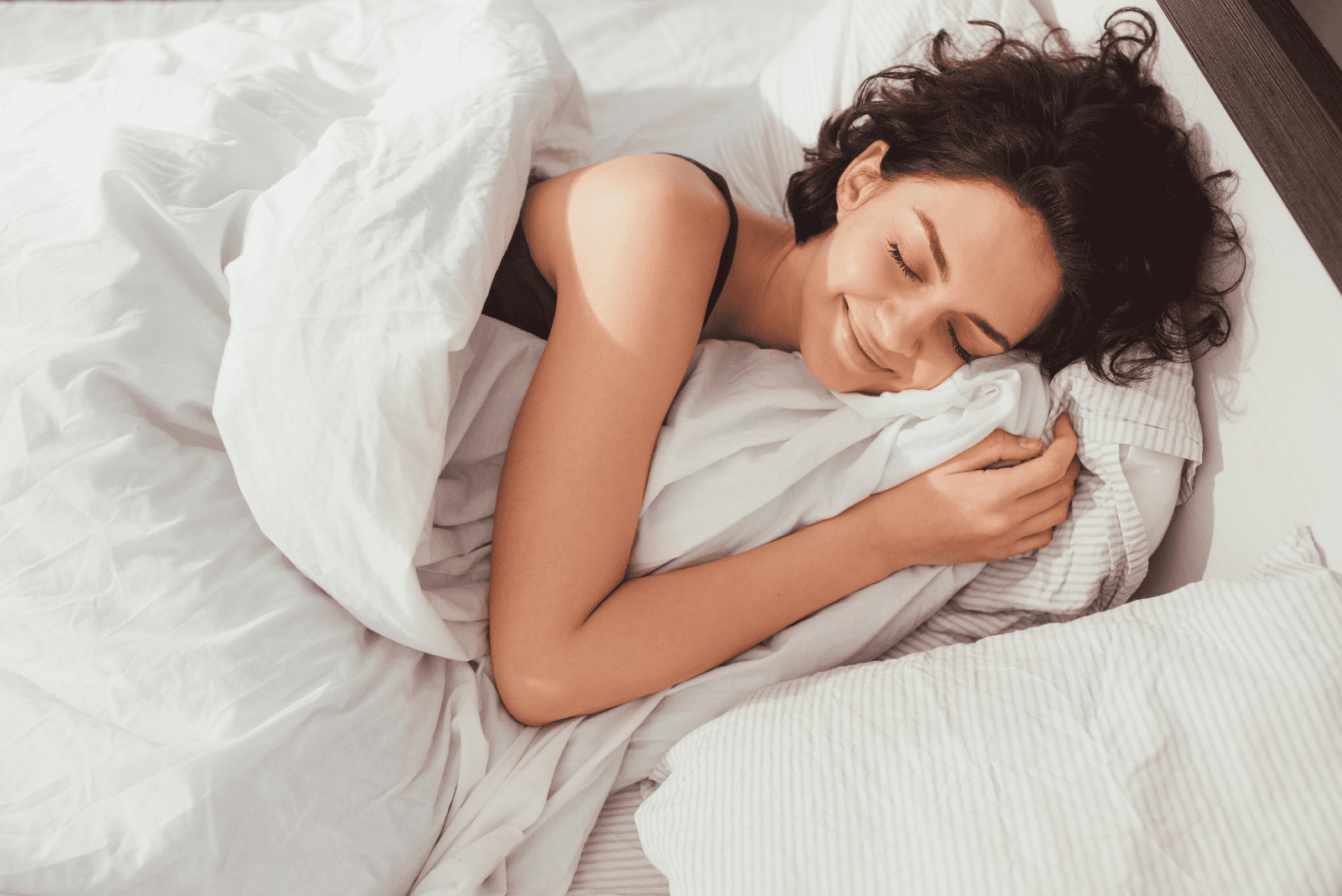 femme souriante dort dans son lit