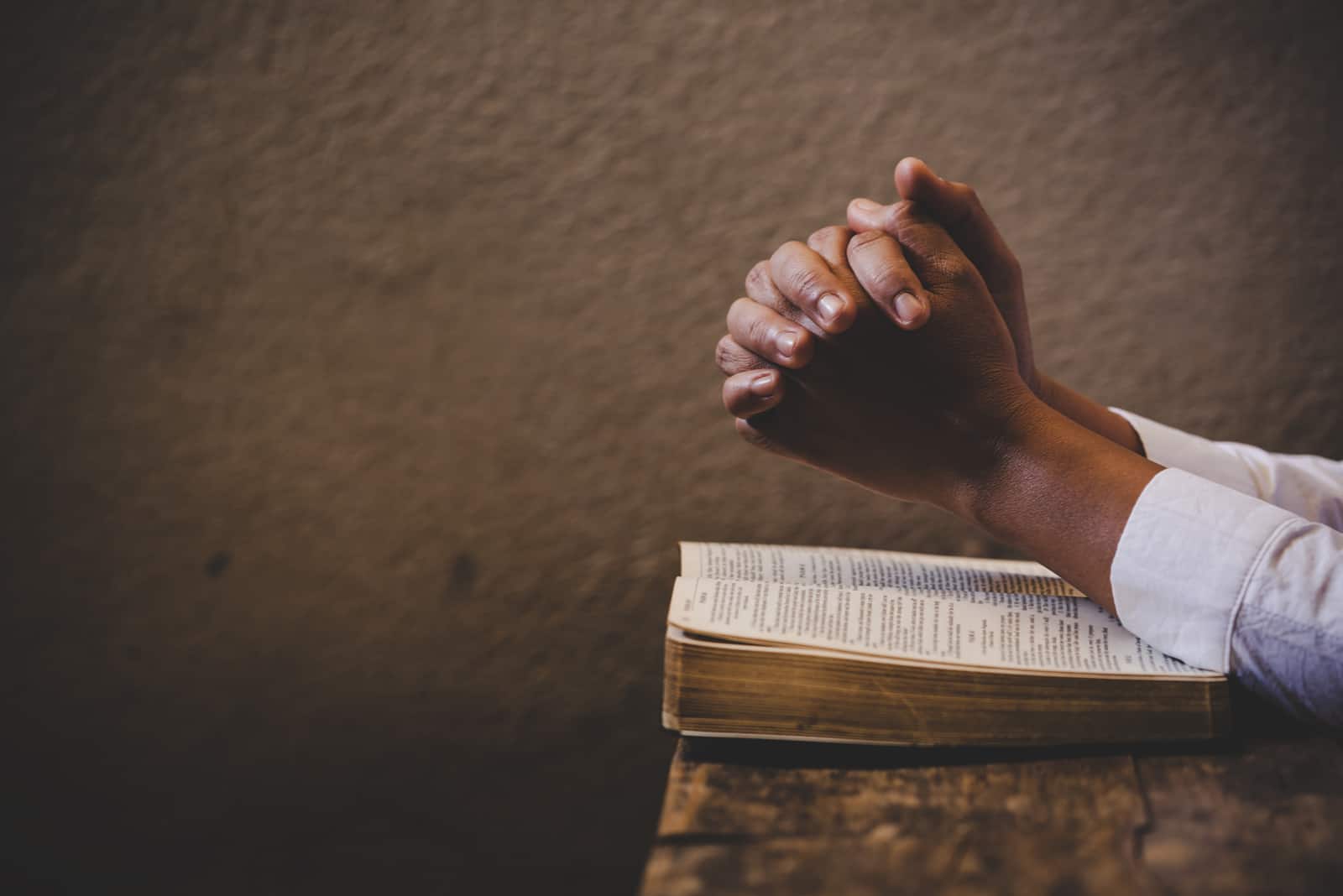 mains en prière sur la bible