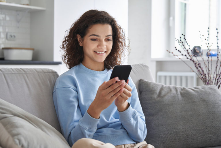 fille assise sur le canapé envoyant des SMS
