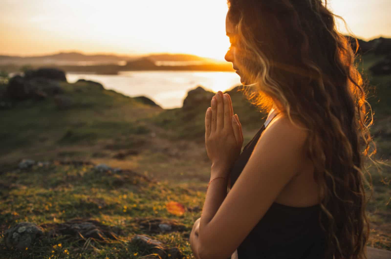 Femme priant seule au lever du soleil