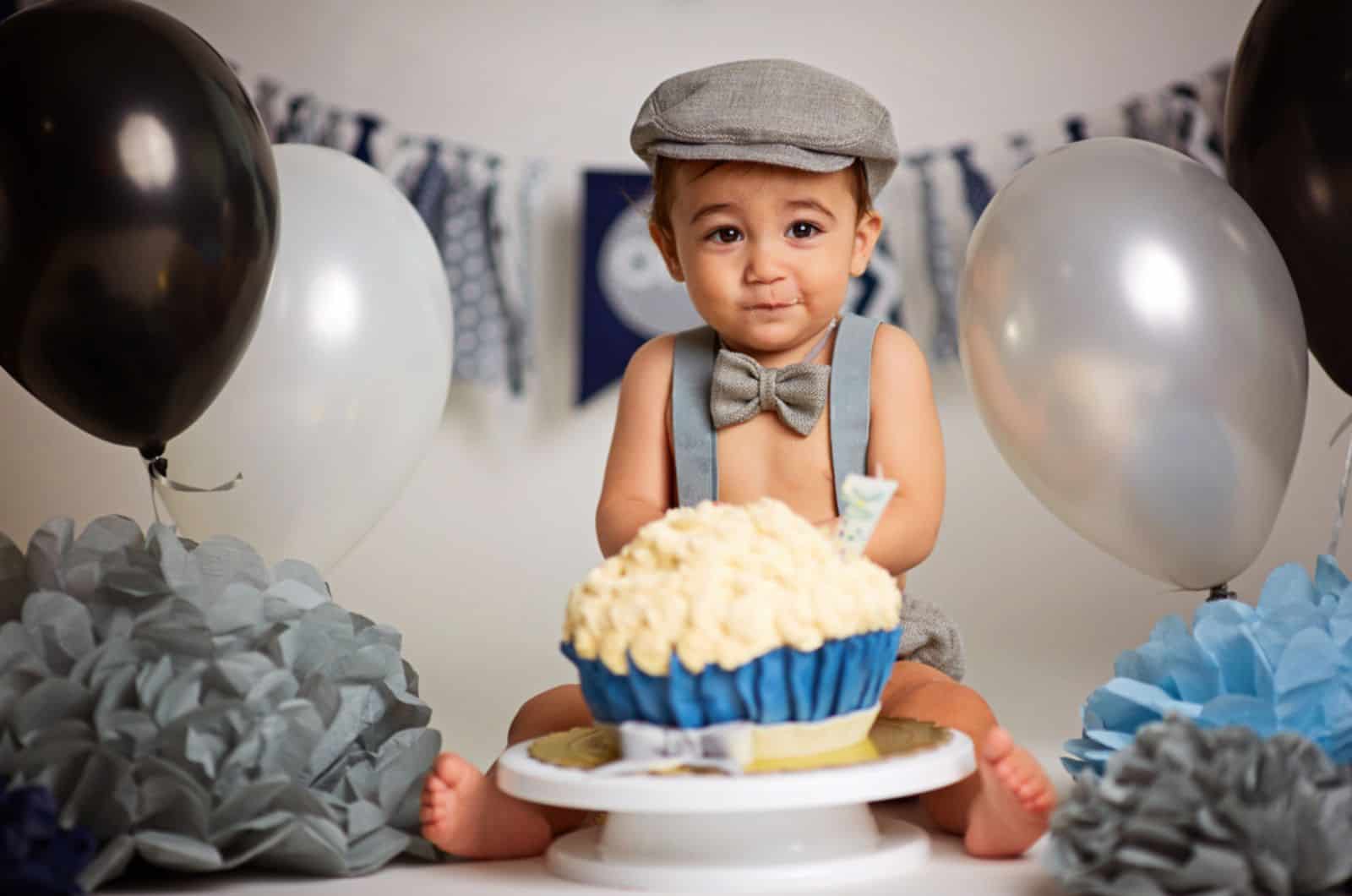 mignon petit garçon pour son premier anniversaire avec un gâteau smash