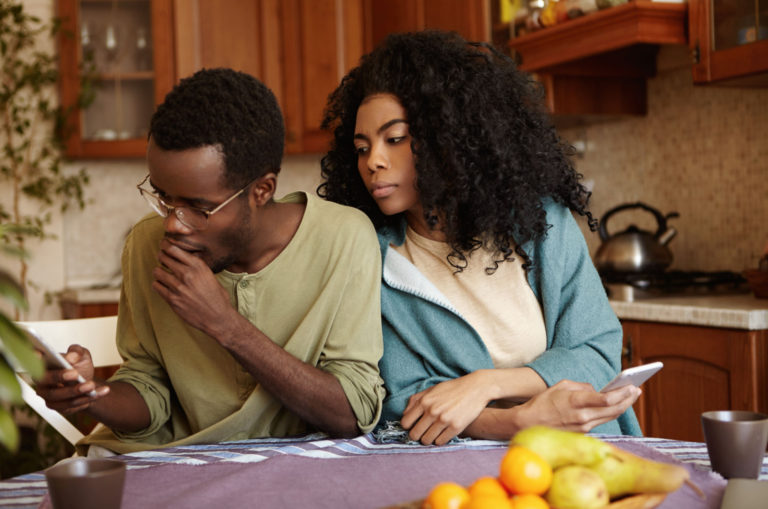 femme paranoïaque regardant le téléphone de son partenaire