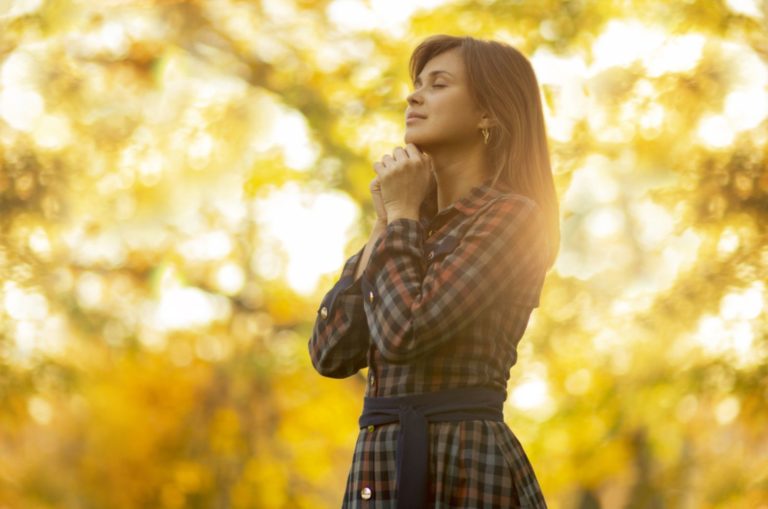 jeune femme priant dans la nature