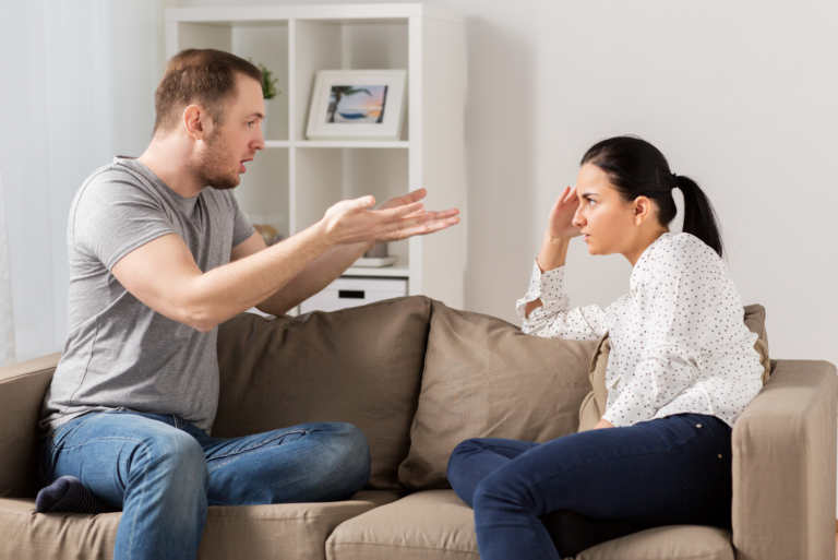 un homme et une femme sont assis sur le canapé et se disputent