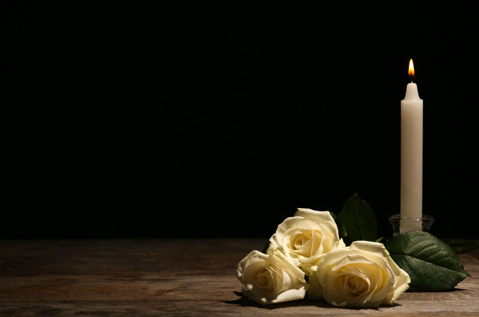 bougie blanche et fleurs pour les funérailles