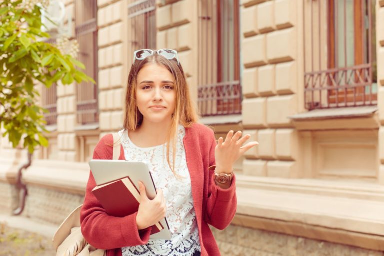 jeune femme avec des livres debout en plein air