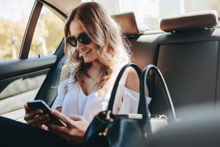 femme qui envoie des textos assise dans une voiture