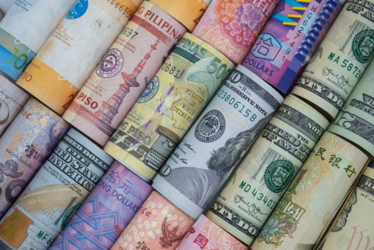 Gros plan roulé de billets de banque variés dans le monde entier