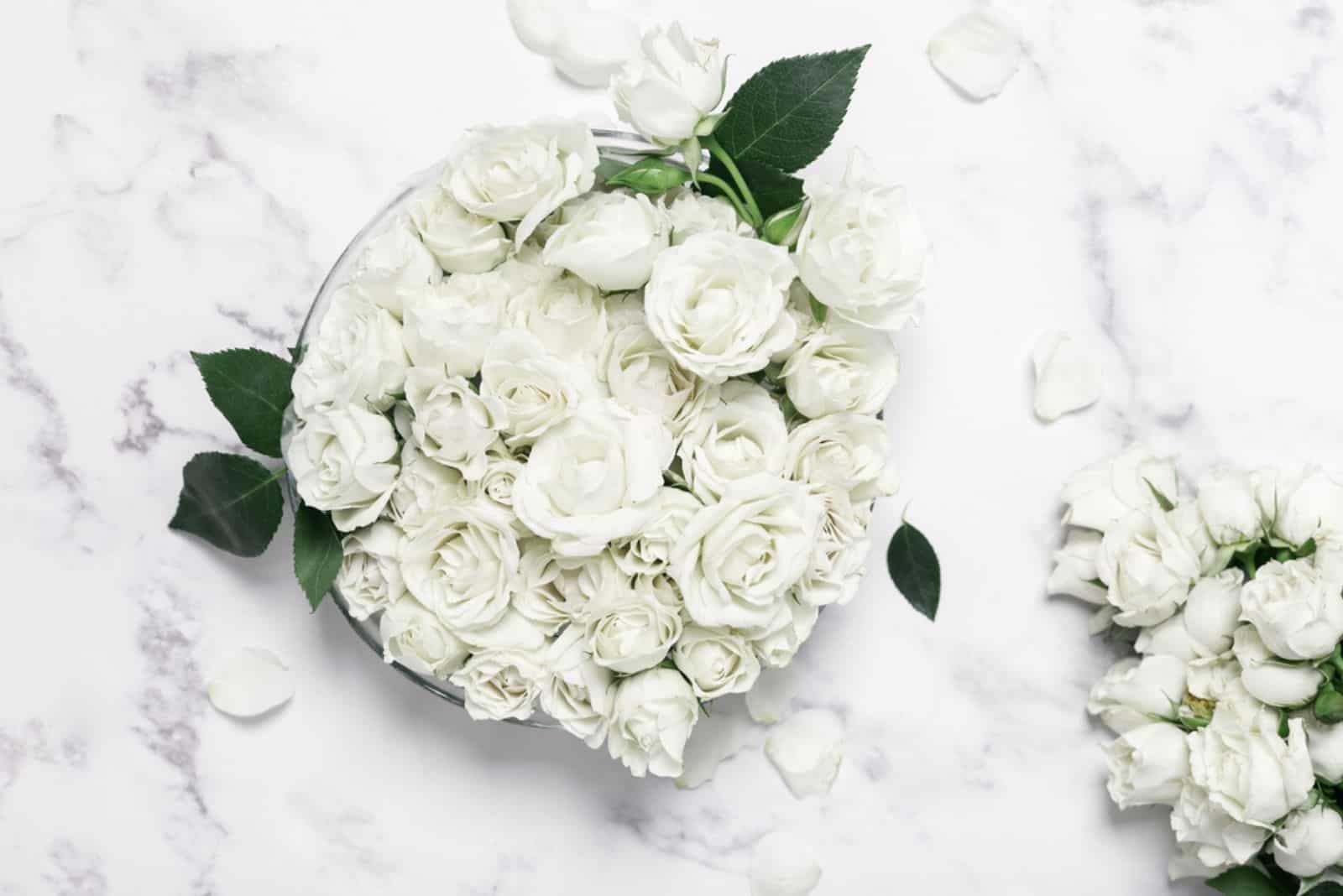 bouquet decoratif fait maison avec des roses blanches sur une table en marbre