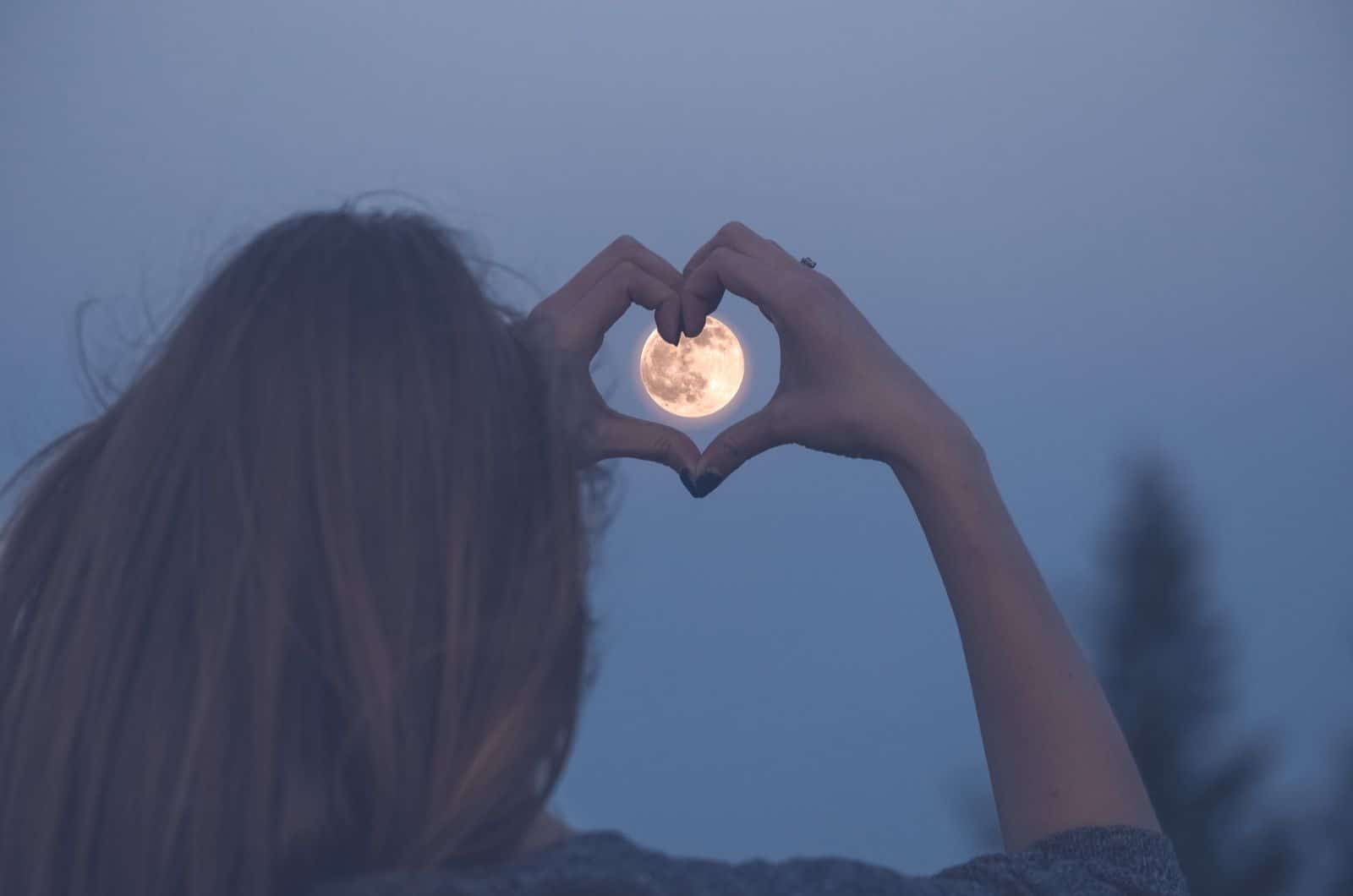 femme faisant coeur avec les mains sur la pleine lune