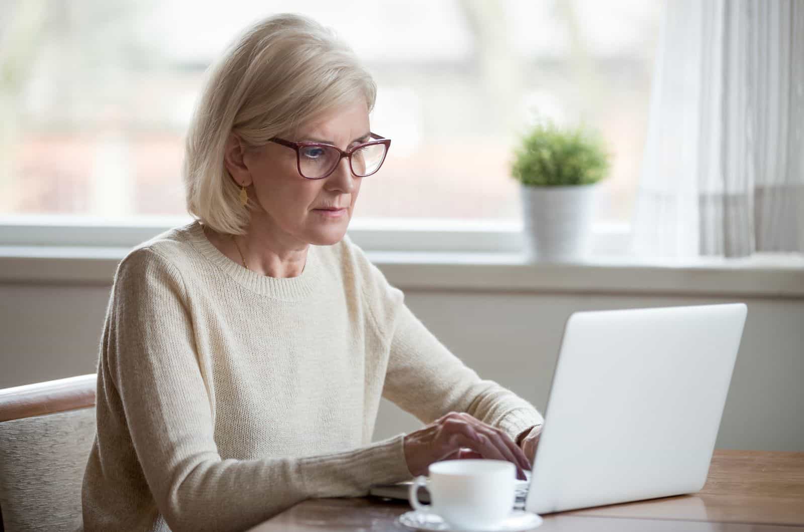 femme plus âgée tapant sur un ordinateur portable