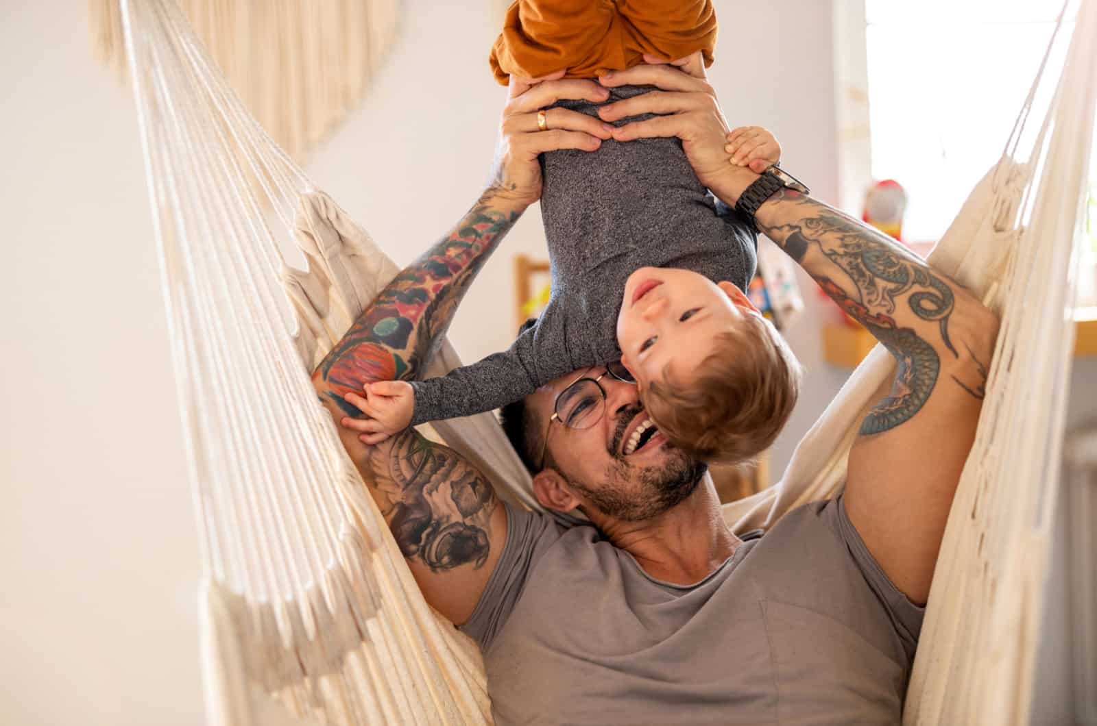 homme tatoué jouant avec son fils