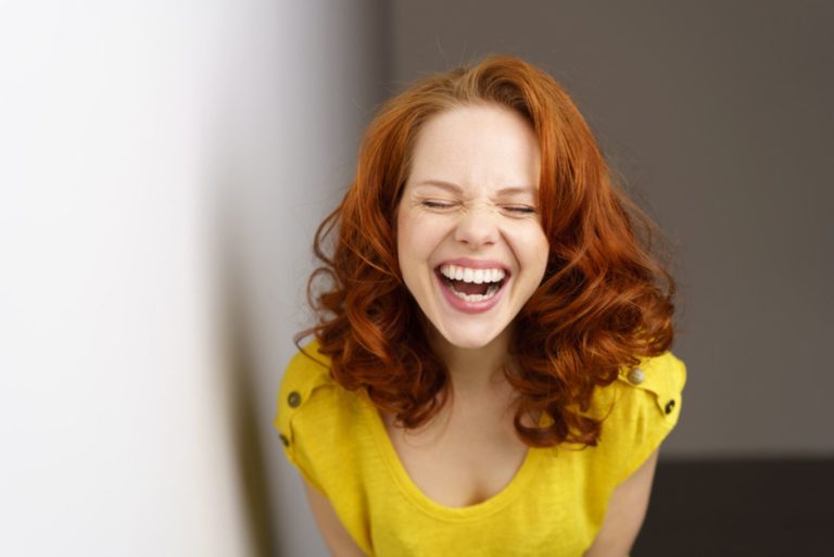 Jolie jeune femme appréciant une bonne blague ayant un rire chaleureux