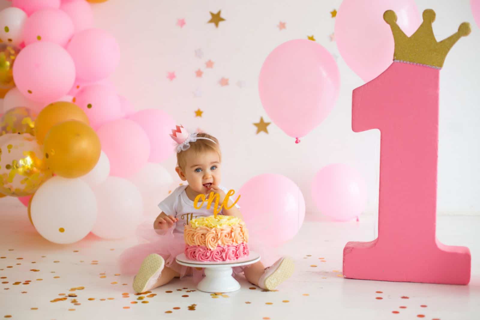 Petite fille au premier anniversaire avec un gâteau smash