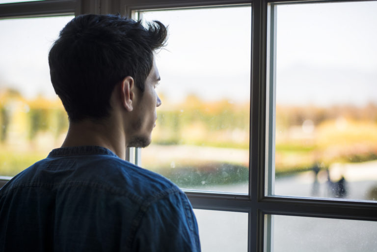 gros plan d'un homme regardant par la fenêtre