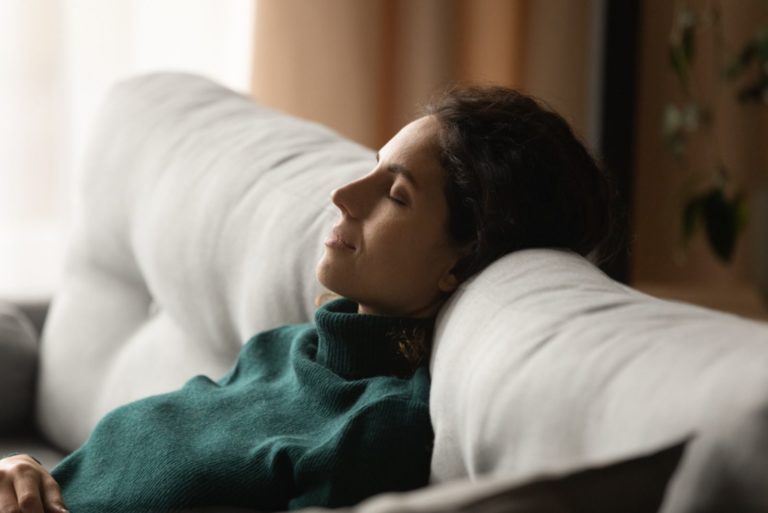 belle fille penchée sur le canapé en train de dormir
