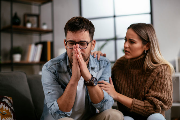 femme réconfortant un homme contrarié