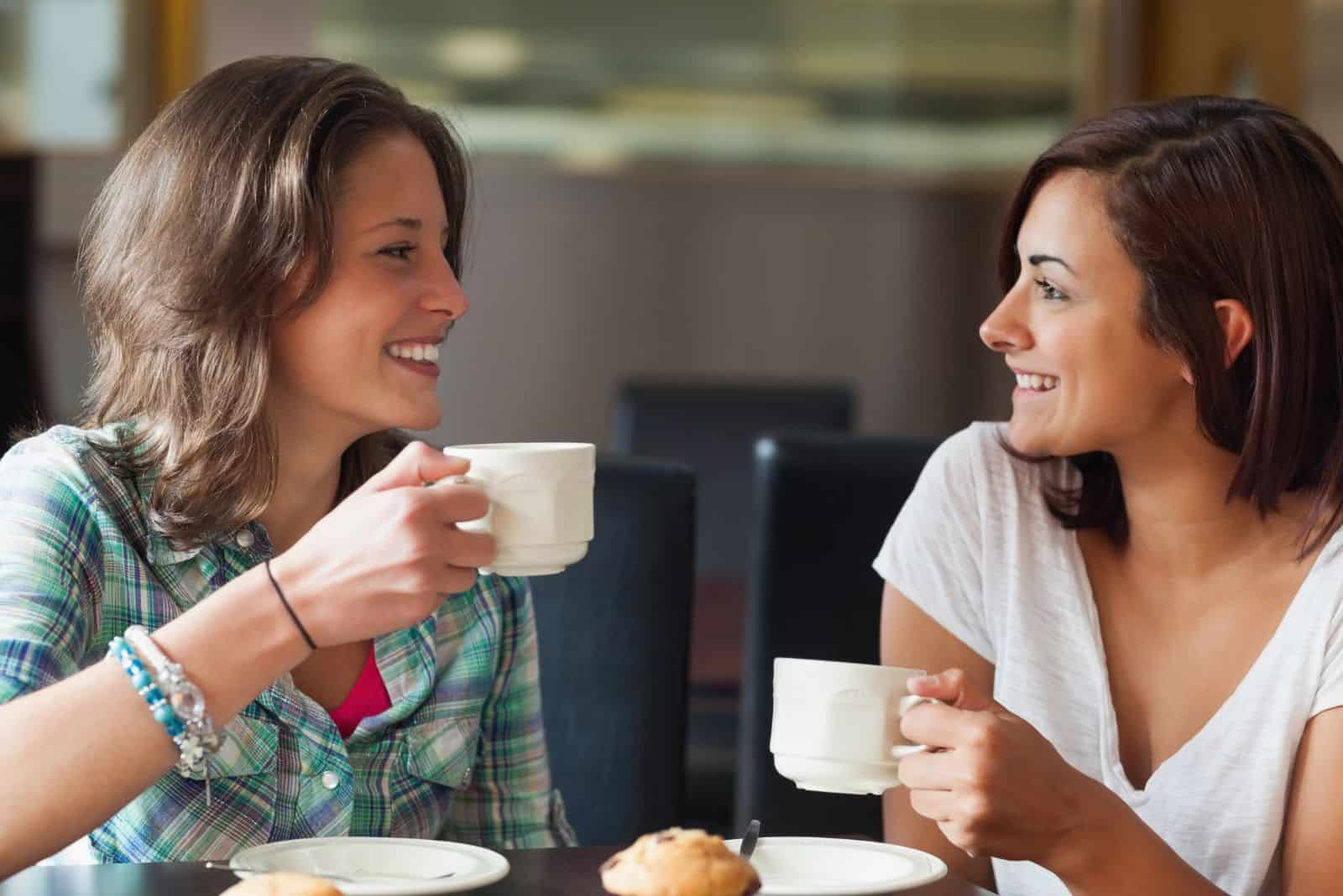 amies souriantes assises et buvant du café