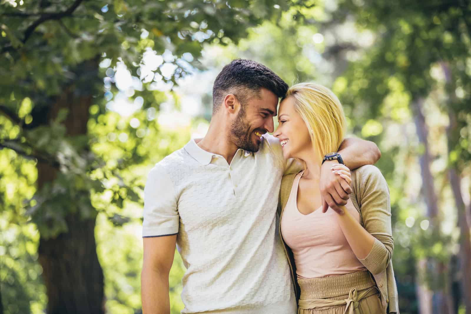 couple heureux marchant dans le parc tout en câlin