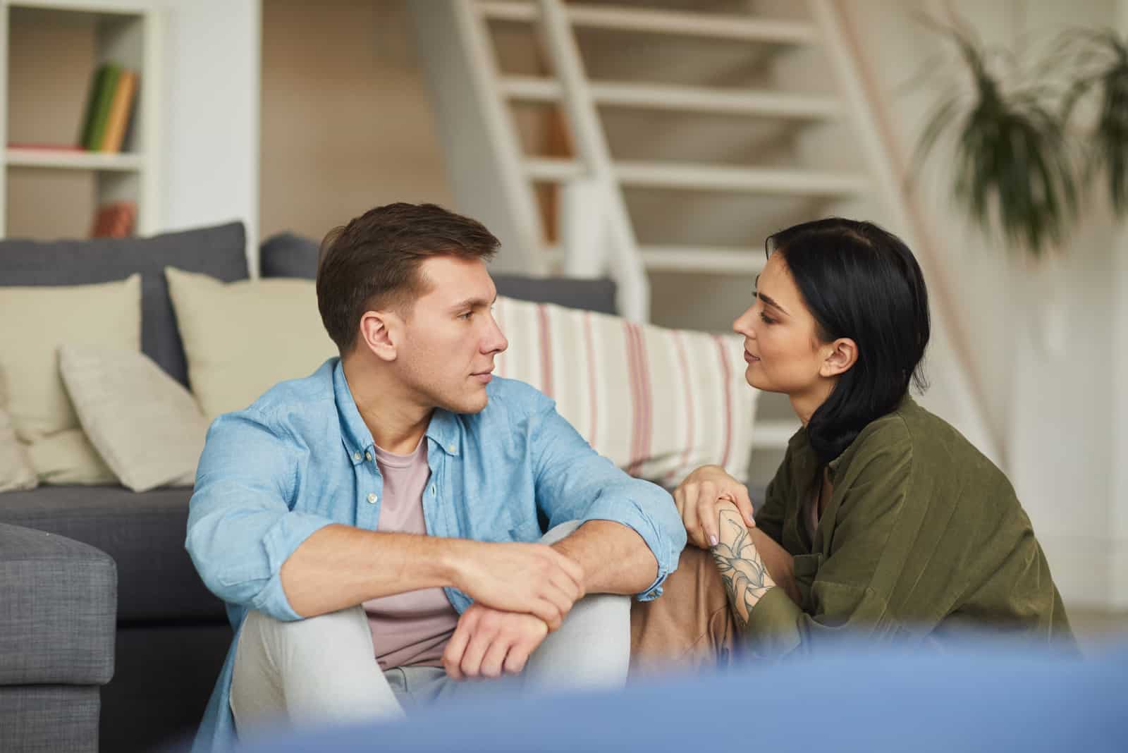 couple parlant par terre à la maison