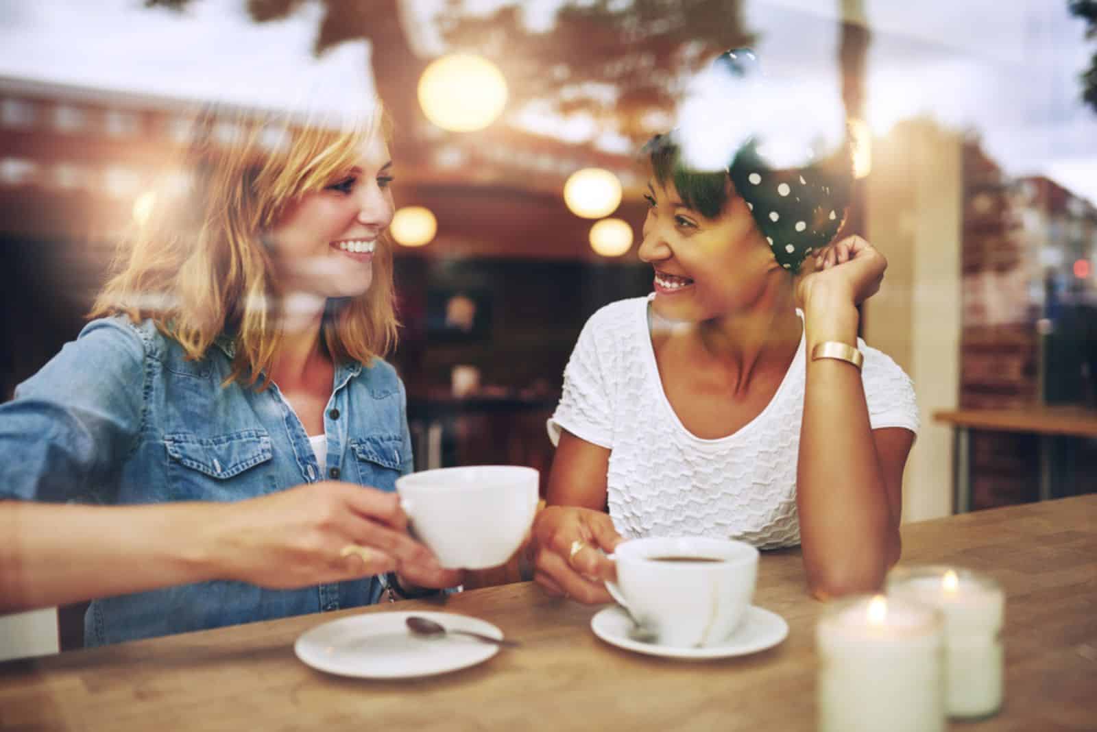 des amis souriants sont assis dans un café