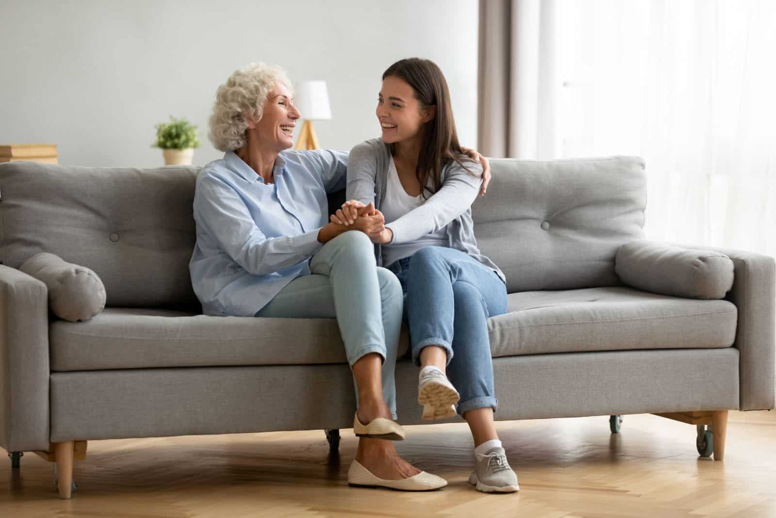 deux belles femmes sont assises sur le canapé et parlent