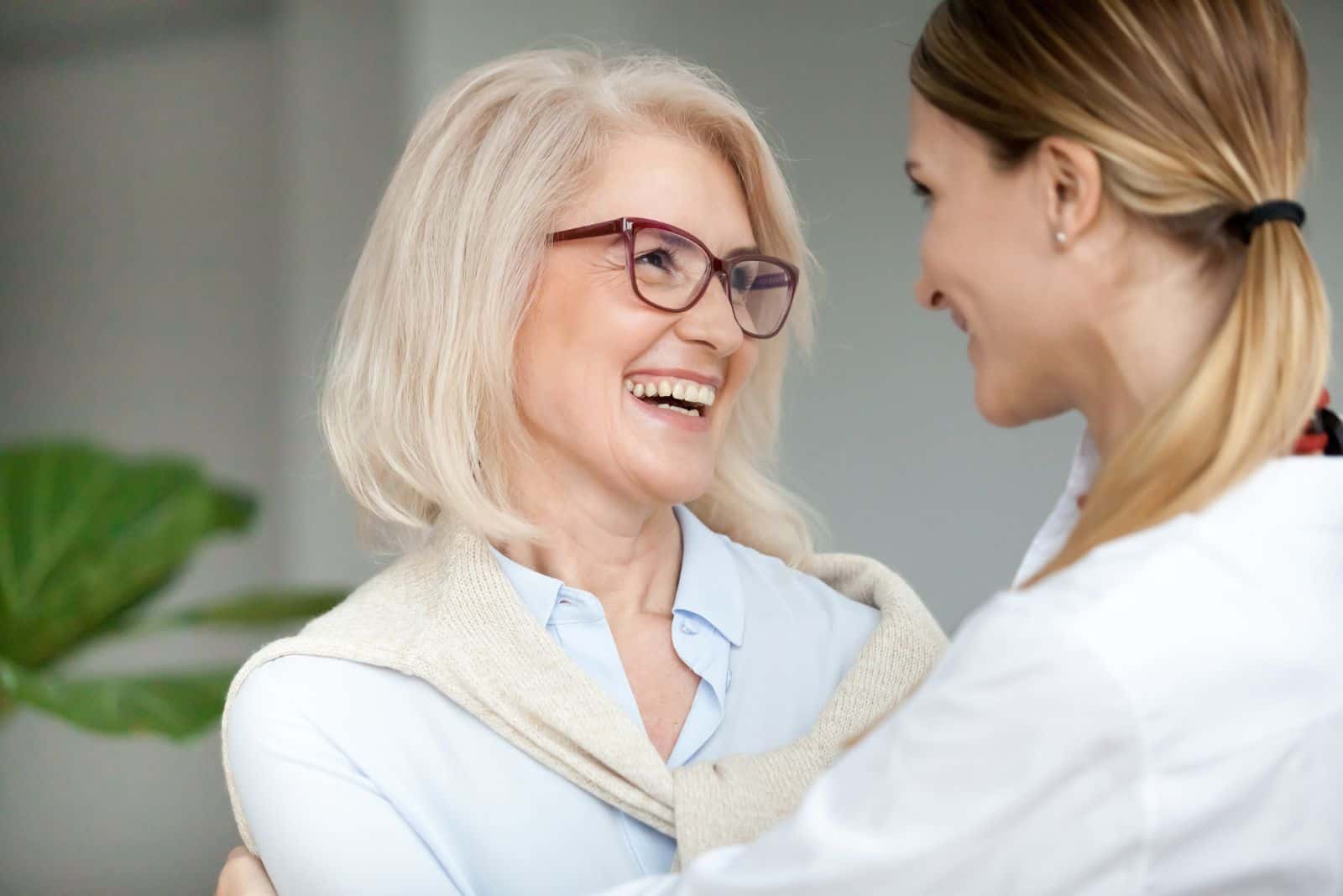 deux femmes souriantes sont debout et parlent