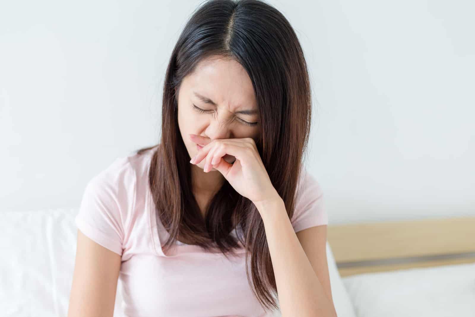 femme irritée se gratte le nez