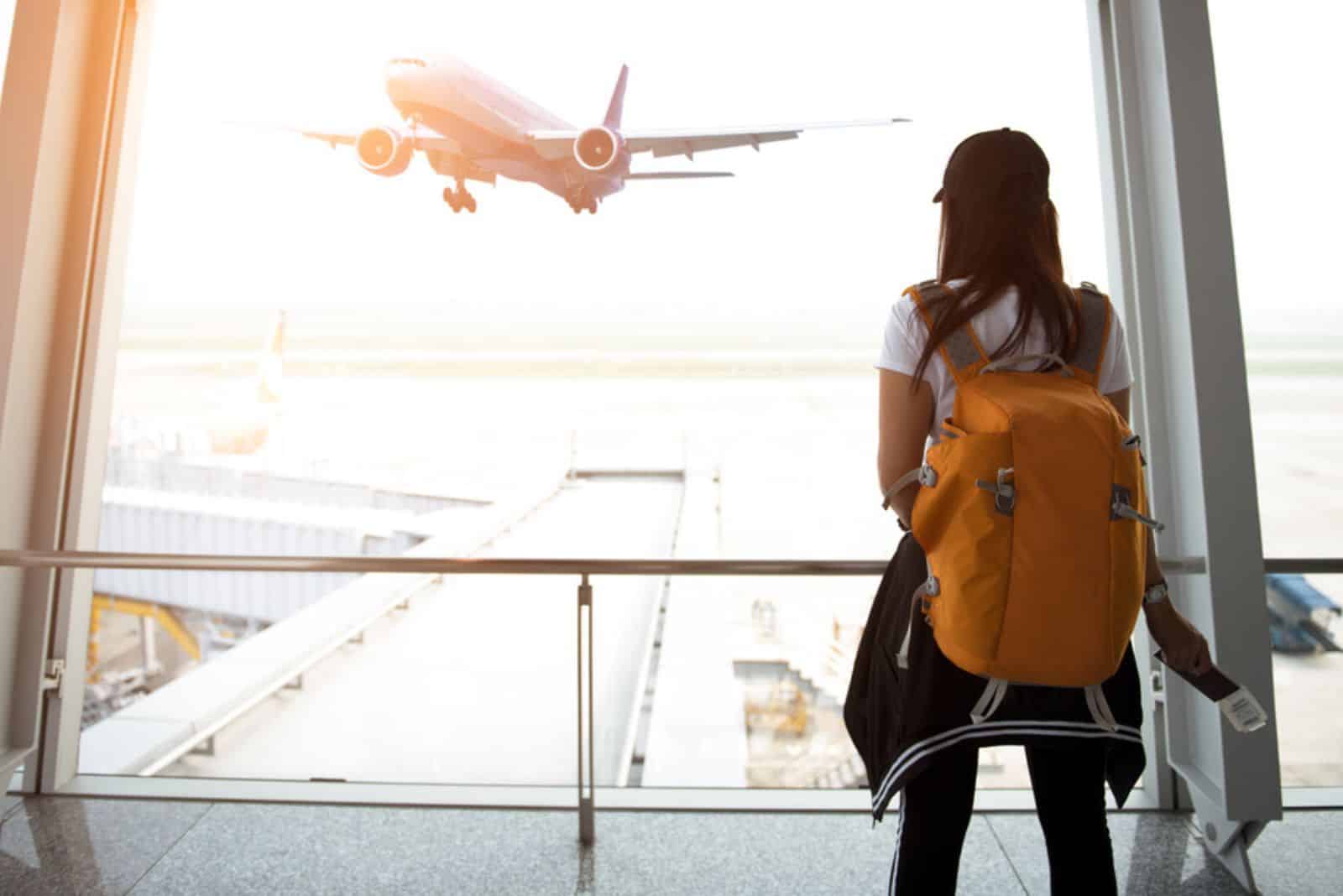 femme voyageuse avec sac à dos regardant l'avion