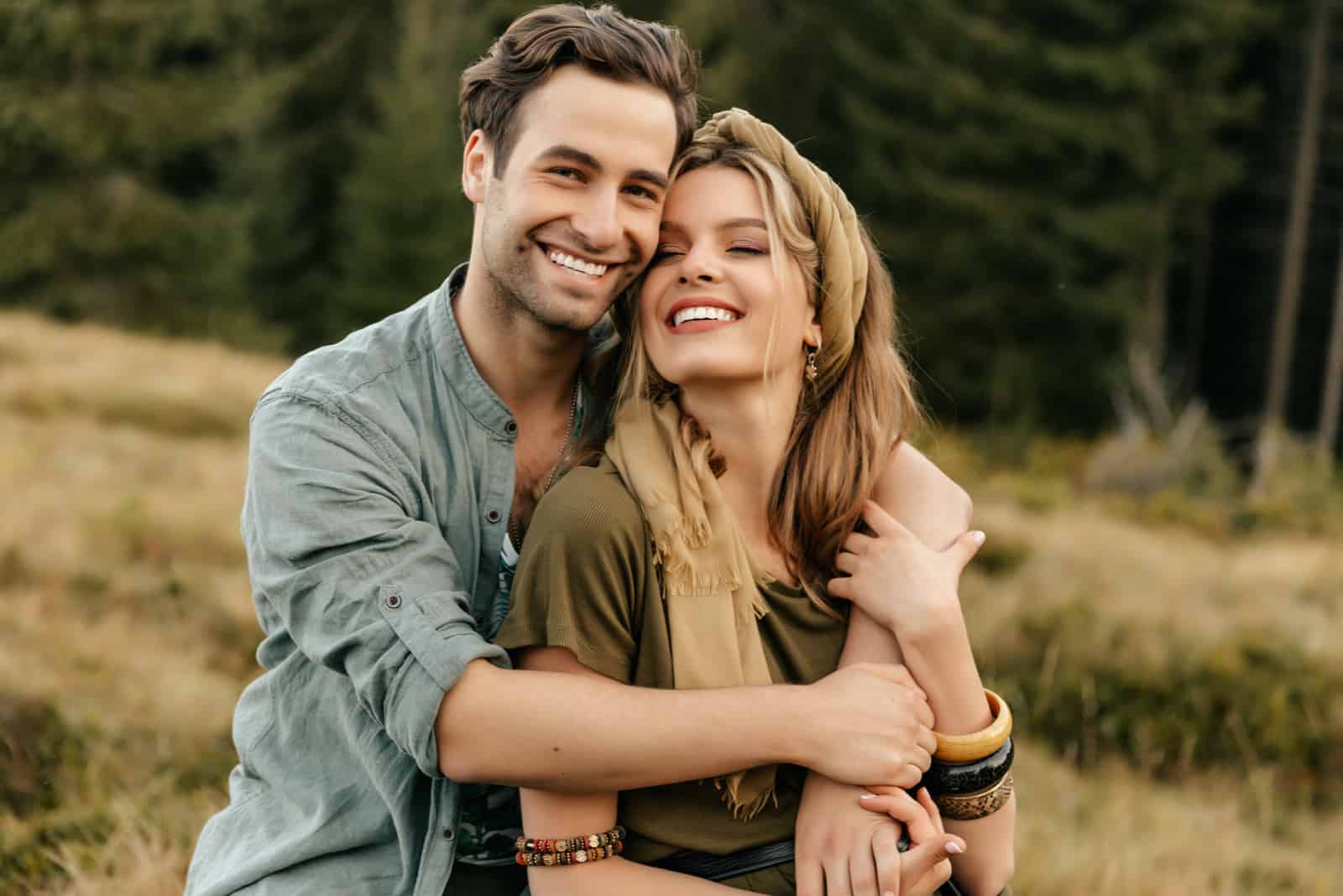 jeune couple souriant posant dans la nature