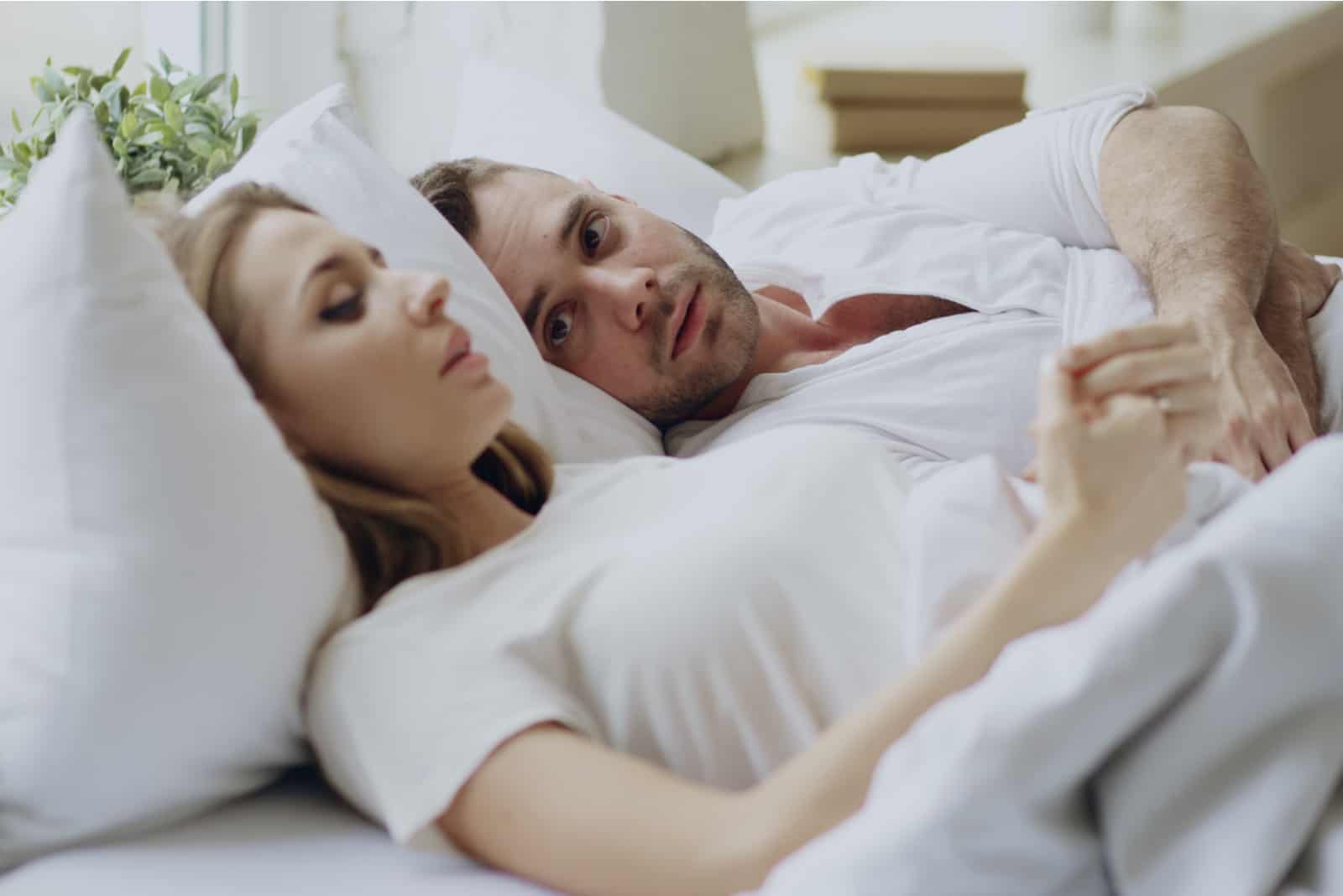 l'homme regarde la femme pendant qu'ils sont au lit