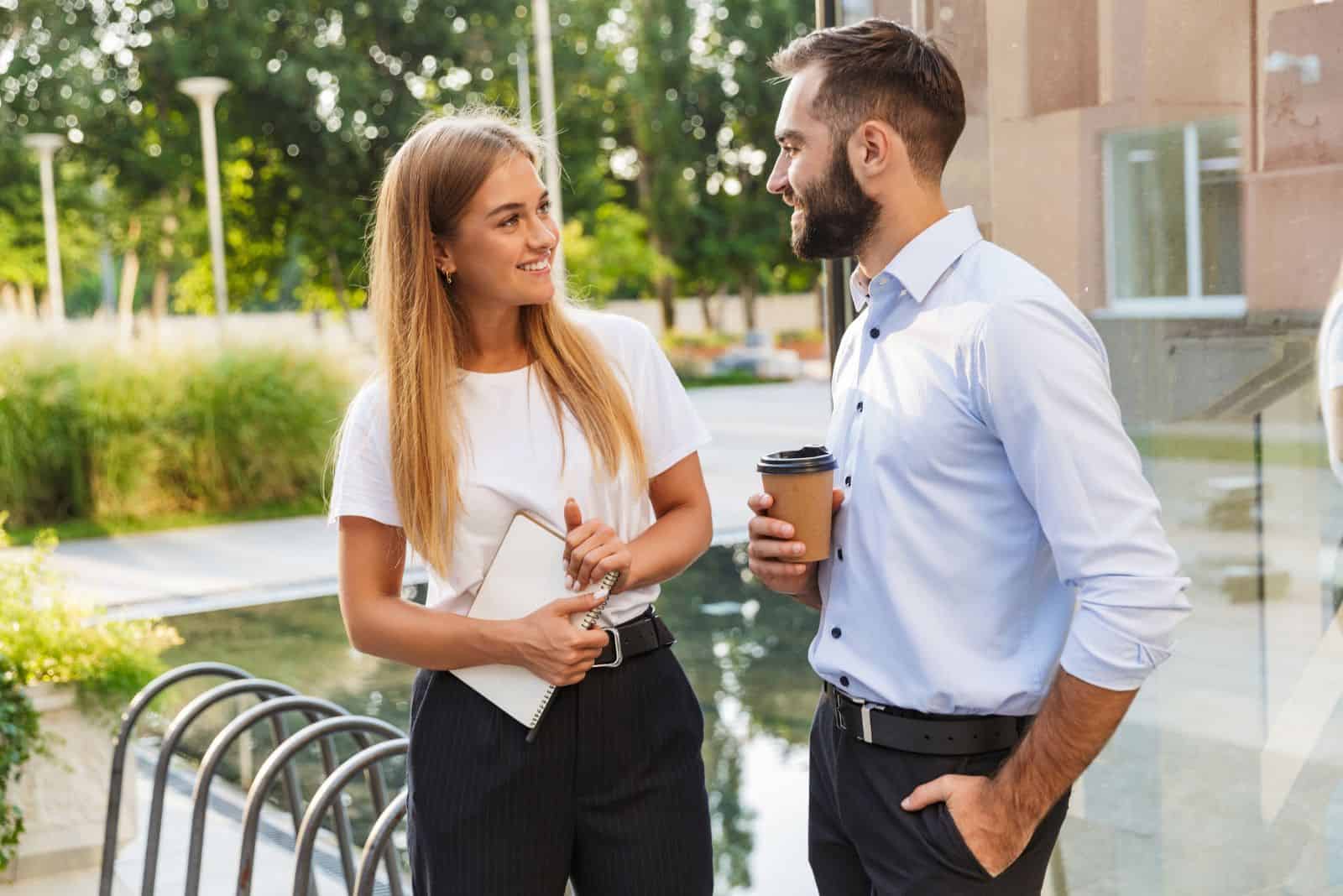 un homme et une femme se tiennent à l'air libre et parlent