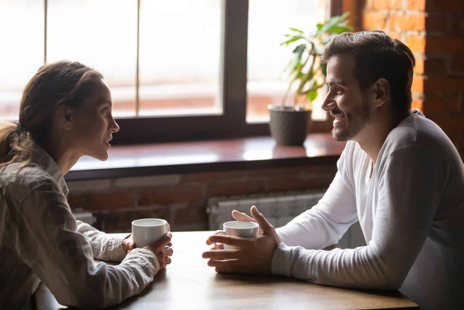 un homme et une femme sont assis à table et parlent