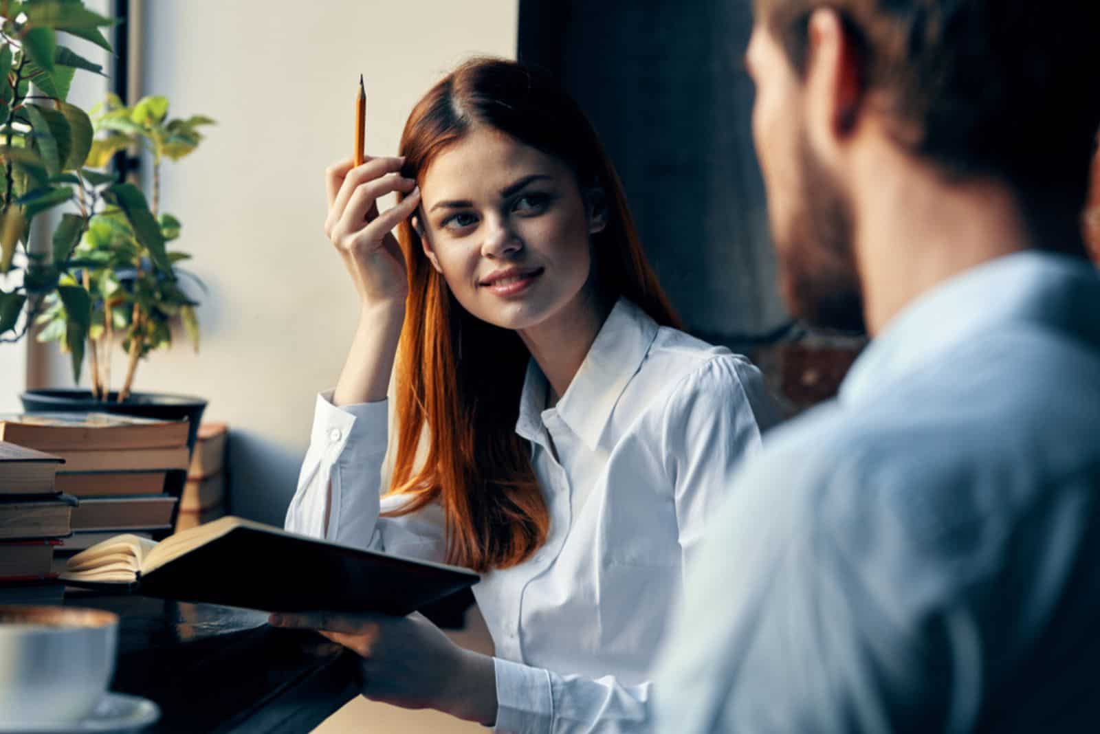 une belle femme est assise à côté d'un homme et ils parlent