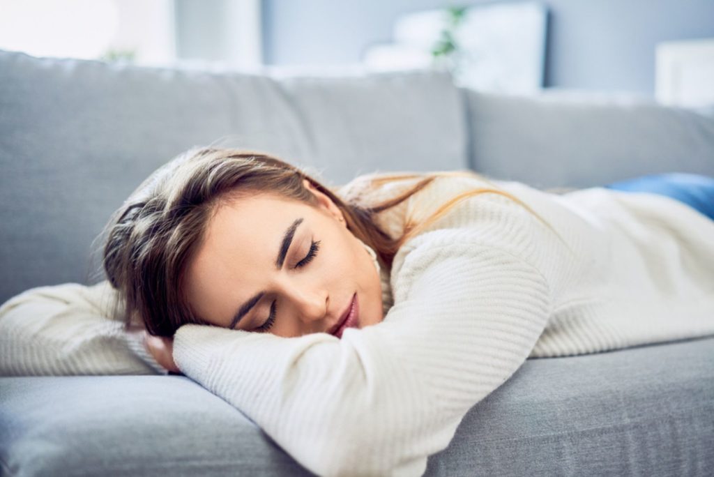 une belle fille dort sur le canapé