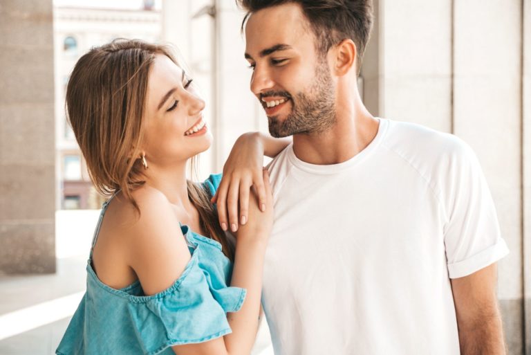 une fille souriante appuyée sur l'épaule d'un homme