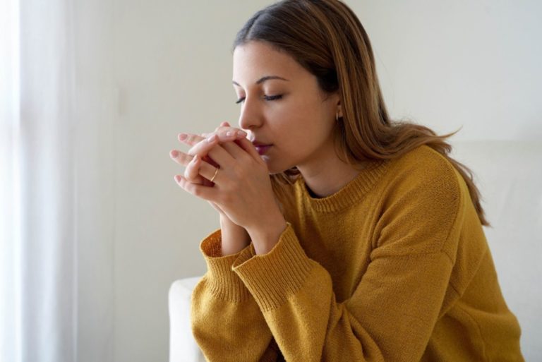 une femme est assise et prie