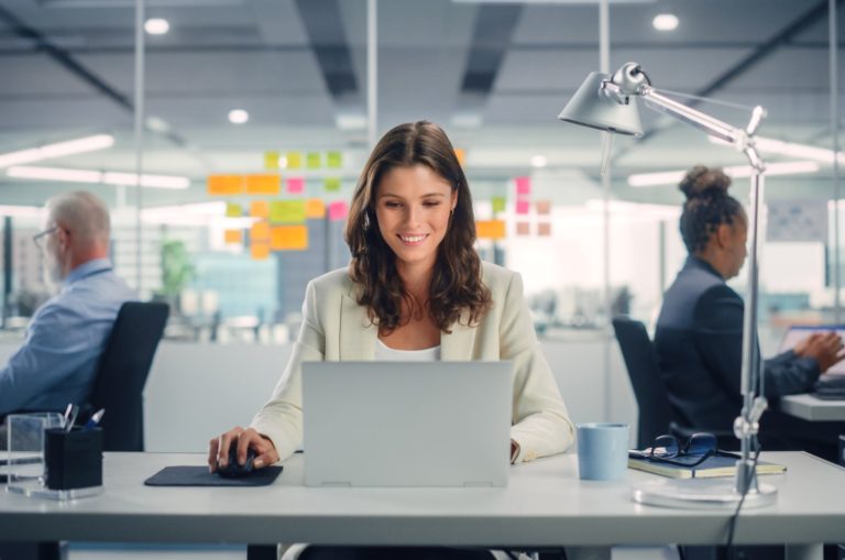 femme heureuse assise près d'une table travaillant