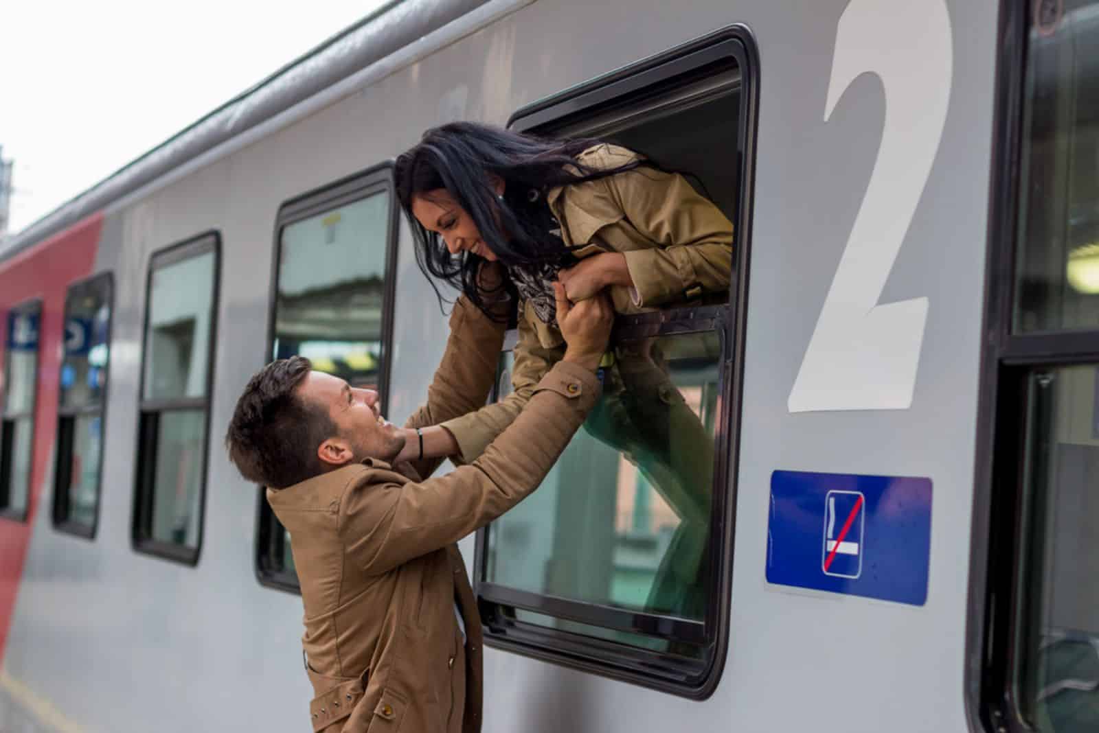 jeune couple sur une gare disant au revoir