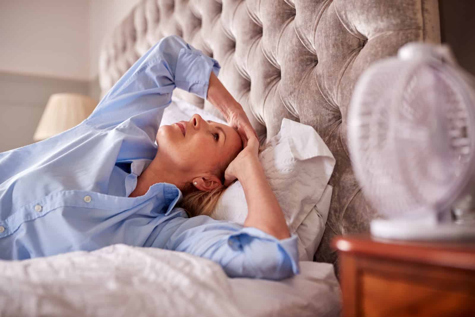 Femme mûre ménopausique souffrant d'insomnie au lit