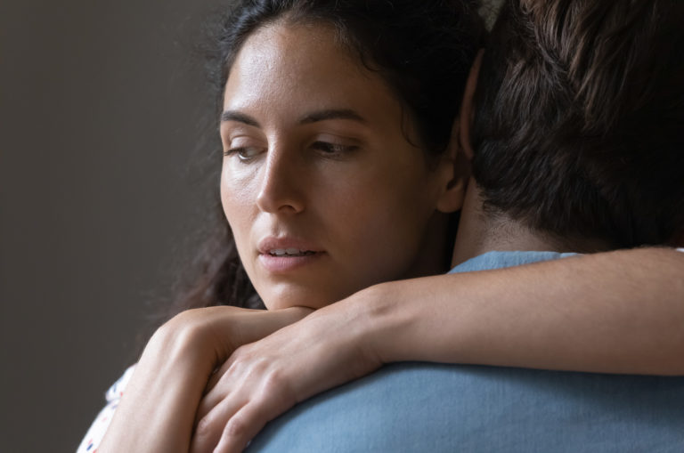 une femme embrasse son petit ami en pensant à un autre homme