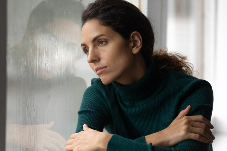 femme triste penchée à la fenêtre