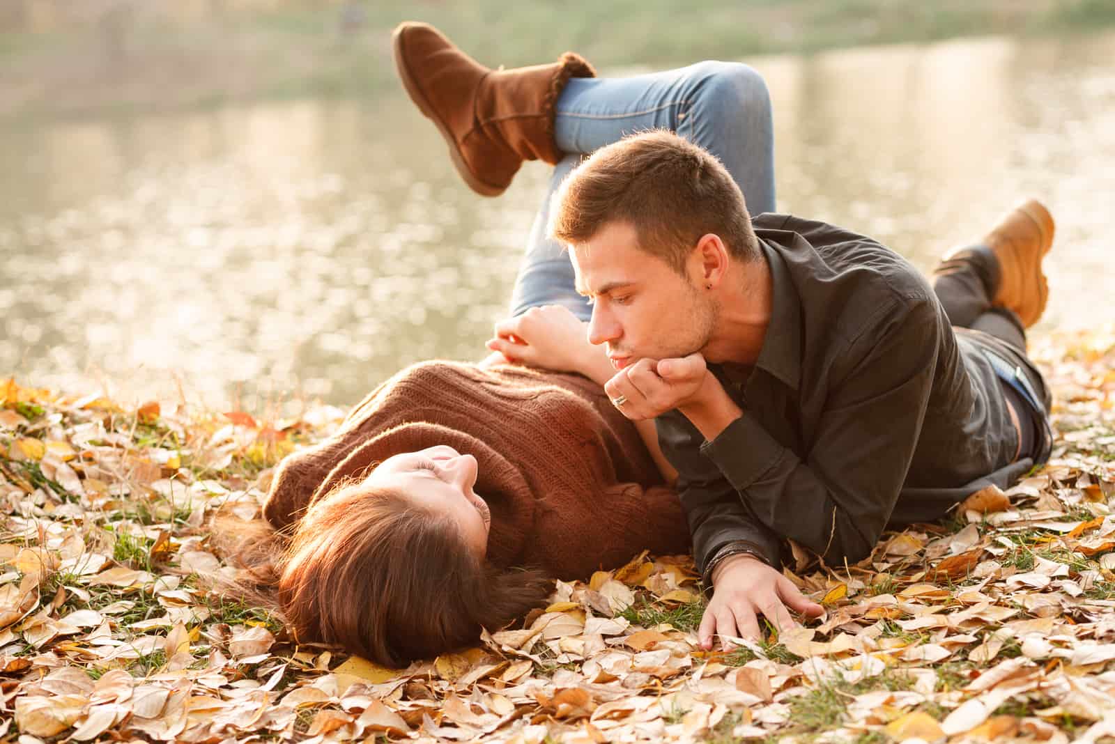 jeune couple allongé sur le sol dans le parc