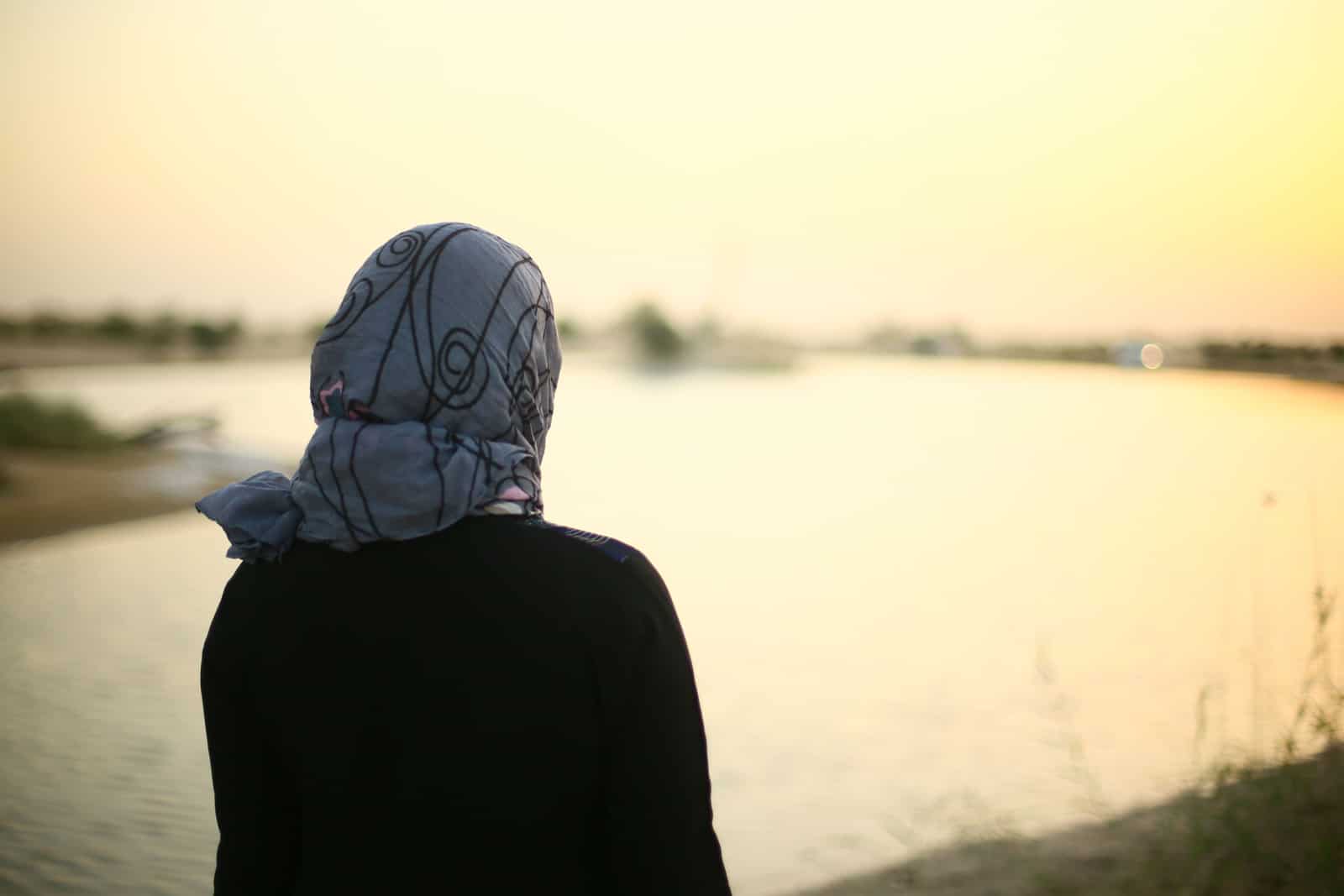 Muslim lady standing near beautiful landscape