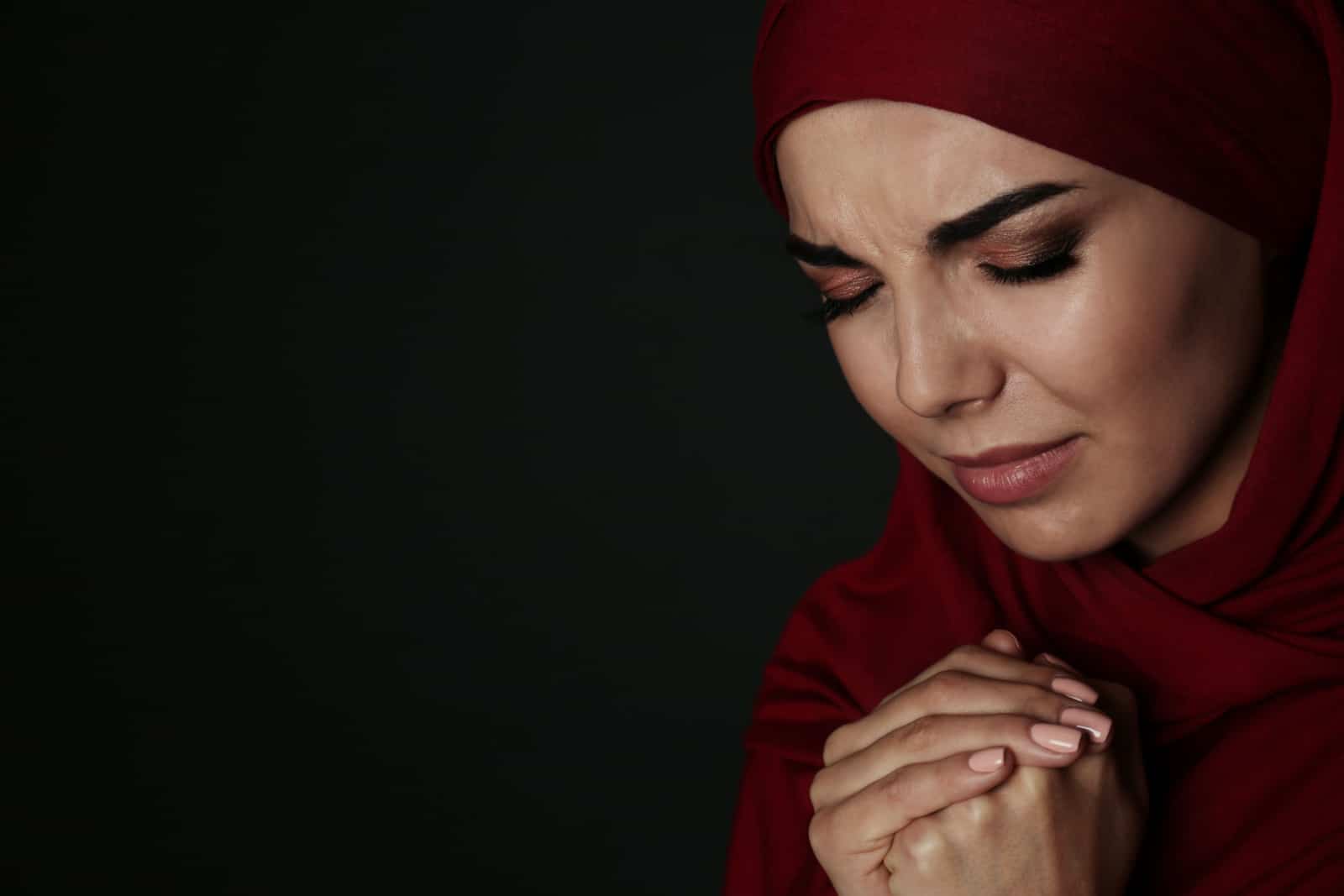 Portrait d'une femme musulmane triste en hijab priant